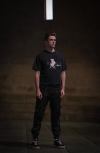 Man wearing theseus tshirt in the street at night